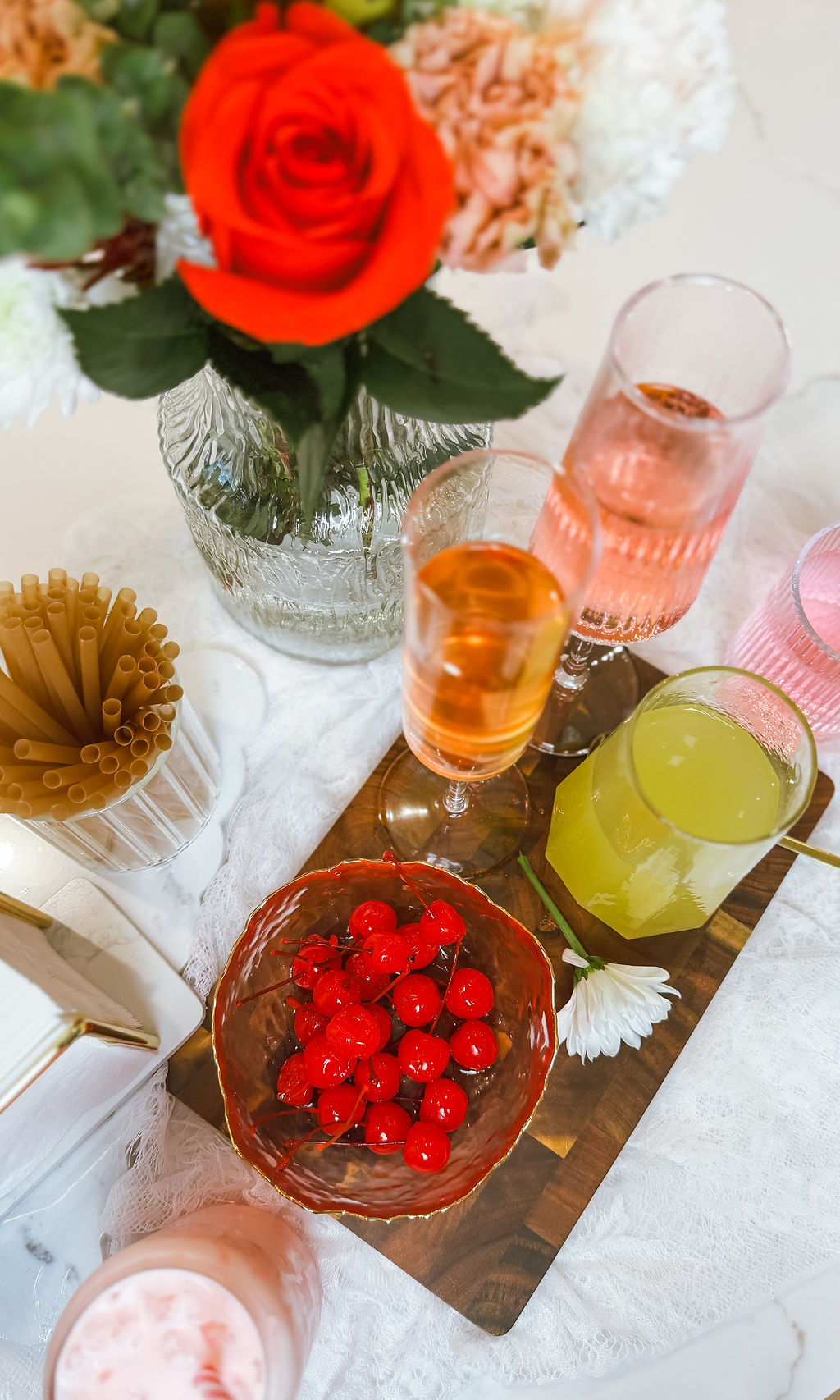 Styled mocktail bar with fresh cherries, glassware, and floral accents