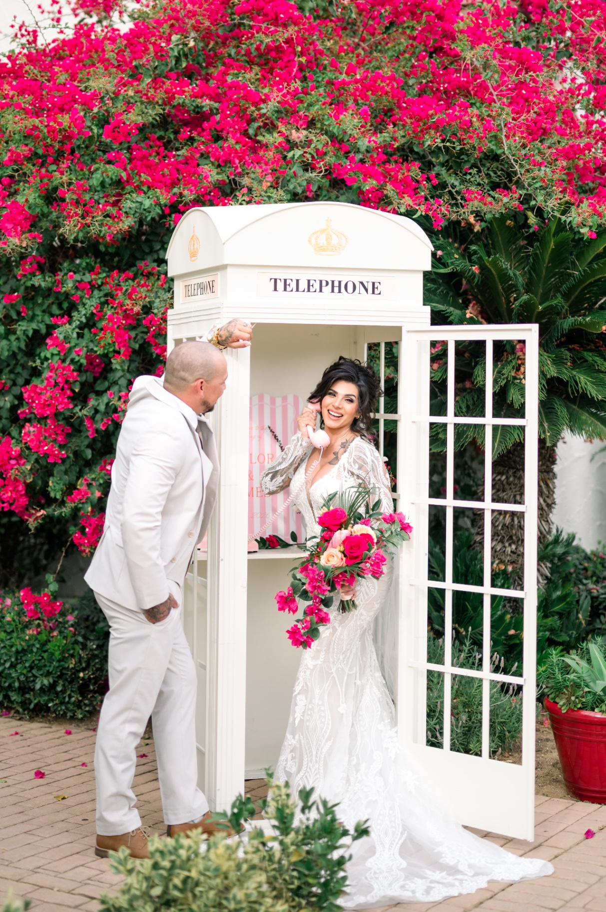 White telephone booth photography installation with floral arrangement at wedding
