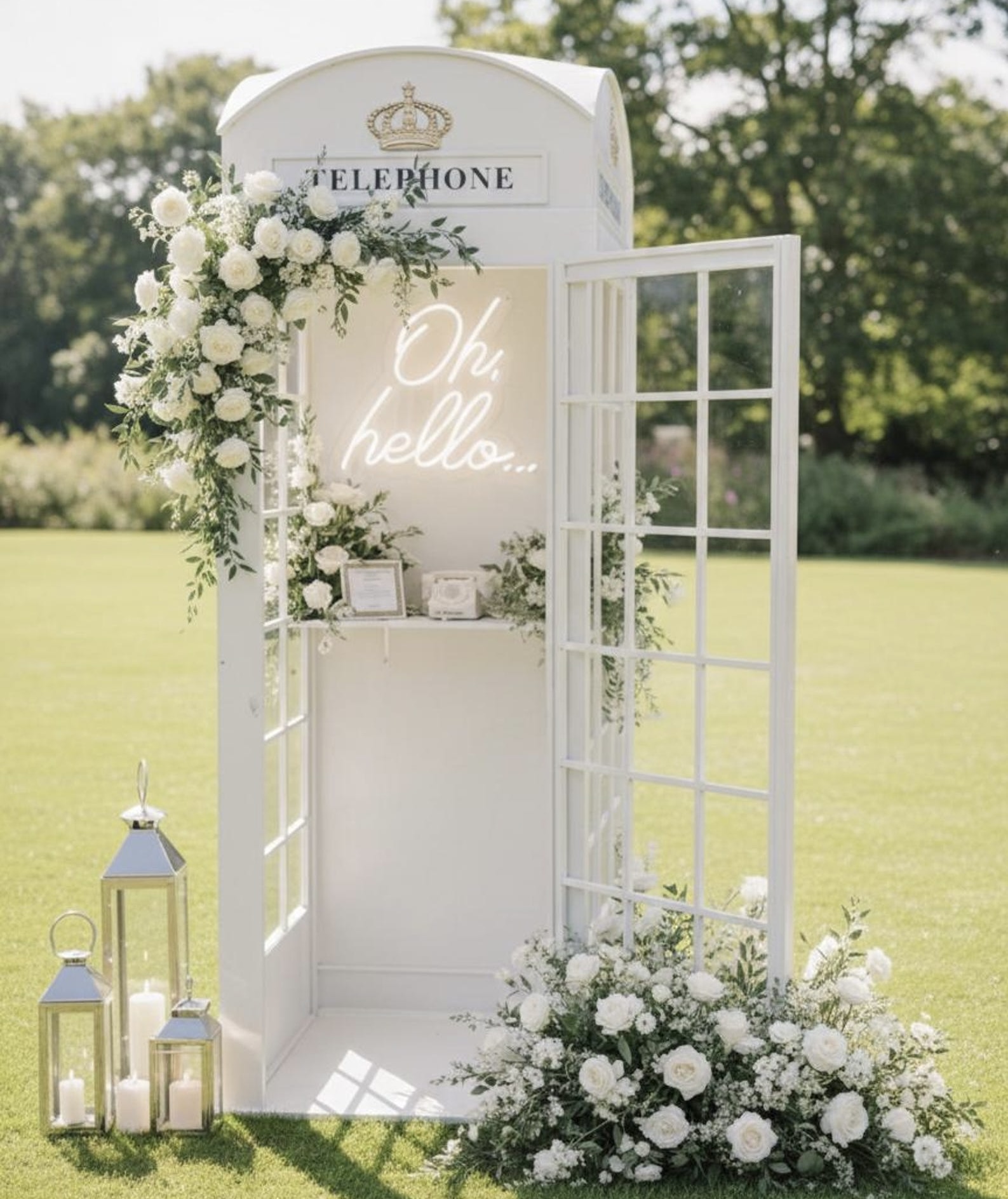 White telephone booth photography installation with floral arrangement at wedding