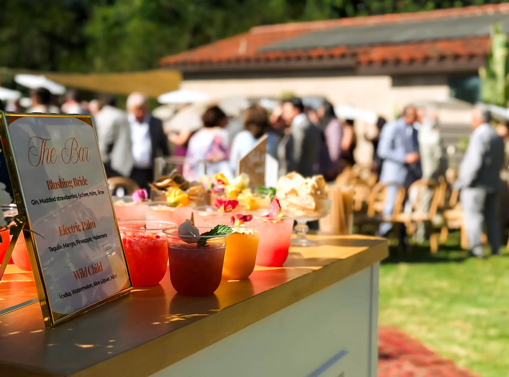 Mobile bar for a Southern California wedding with signature cocktails garnished with edible flowers and mint